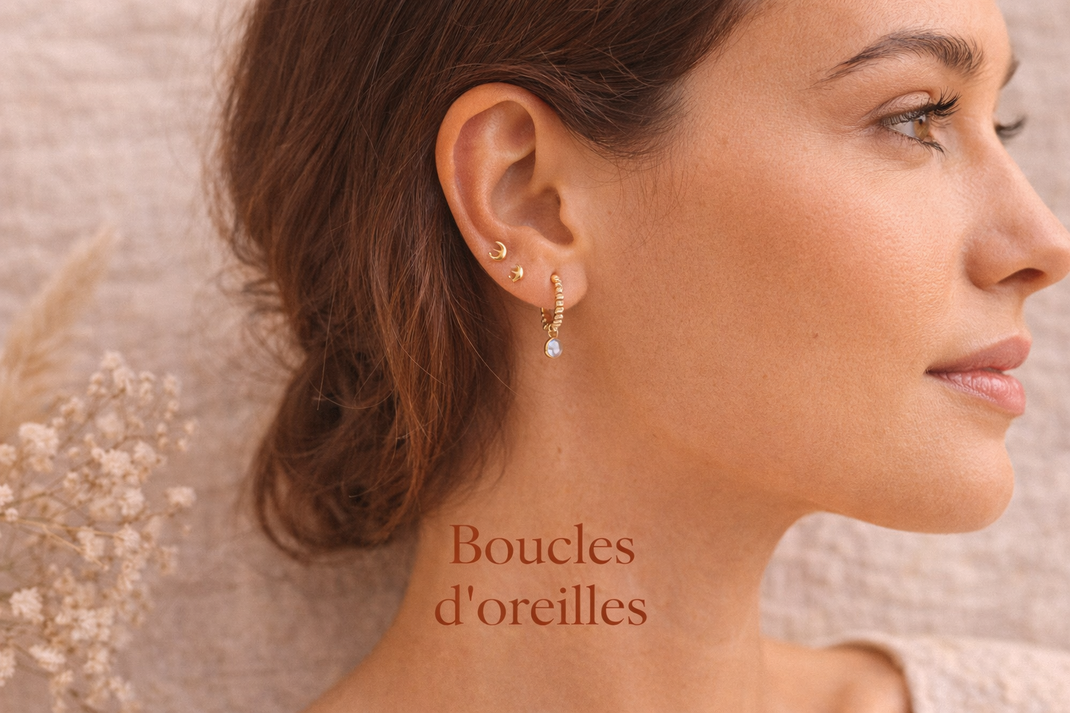 Femme portant plusieurs boucles d'oreilles dorées bohème en acier inoxydable.