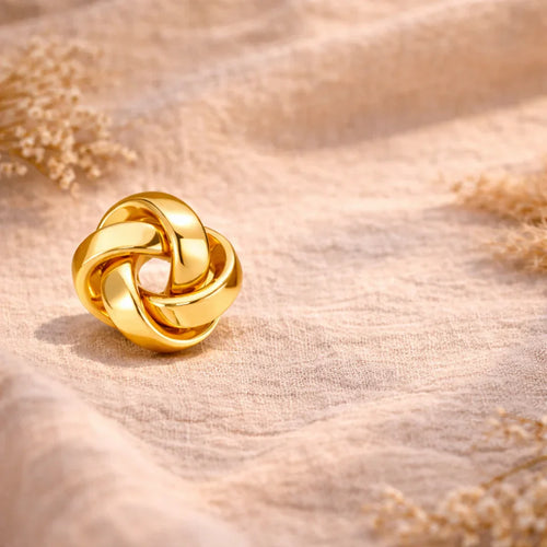 boucles d'oreilles torsadées dorées acier inoxydable sur tissu beige