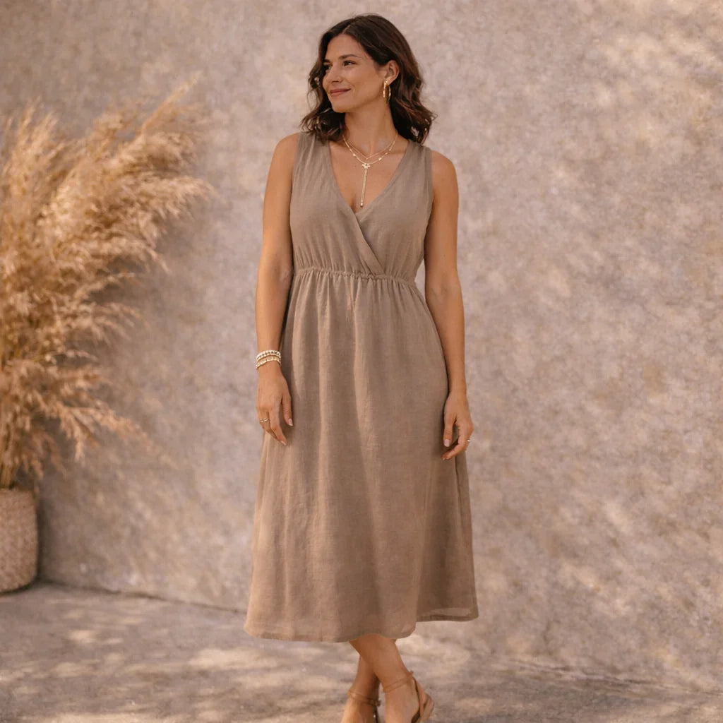 Femme portant une robe beige bohème et bijoux en acier inoxydable, style estival élégant