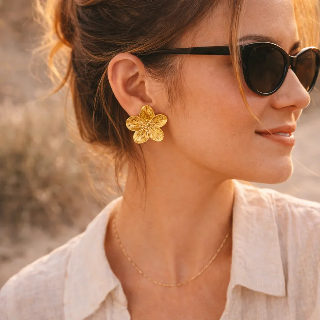 Femme portant boucle d’oreille trèfle dorée bohème en acier inoxydable en extérieur.