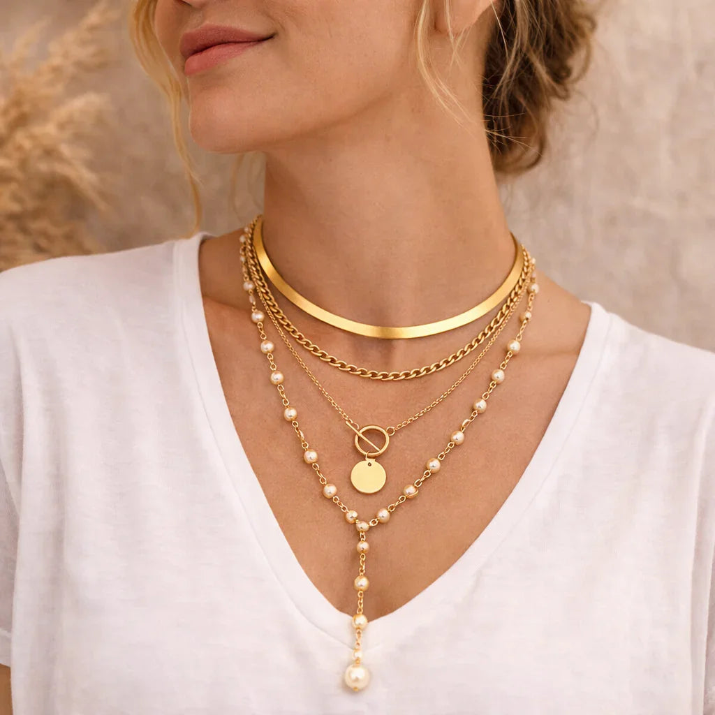 Femme portant colliers multirangs dorés bohèmes avec perles et pendentifs, style élégant